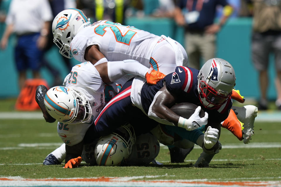 New England Patriots wide receiver Ty Montgomery (14) is tackled by Miami Dolphins linebackers Elandon Roberts (52) and Jerome Baker (55) and safety Brandon Jones (29) during the first half of an NFL football game, Sunday, Sept. 11, 2022, in Miami Gardens, Fla. (AP Photo/Rebecca Blackwell)