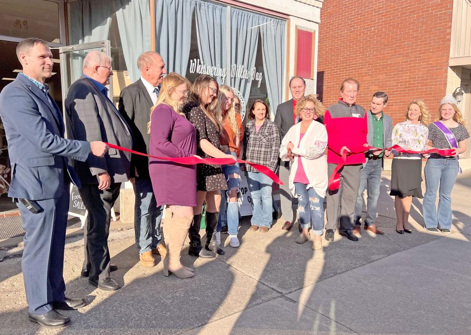 Tonya Bishop cuts a ribbon during the opening of her new store, Whispering Willow Way, in downtown Shelby.
