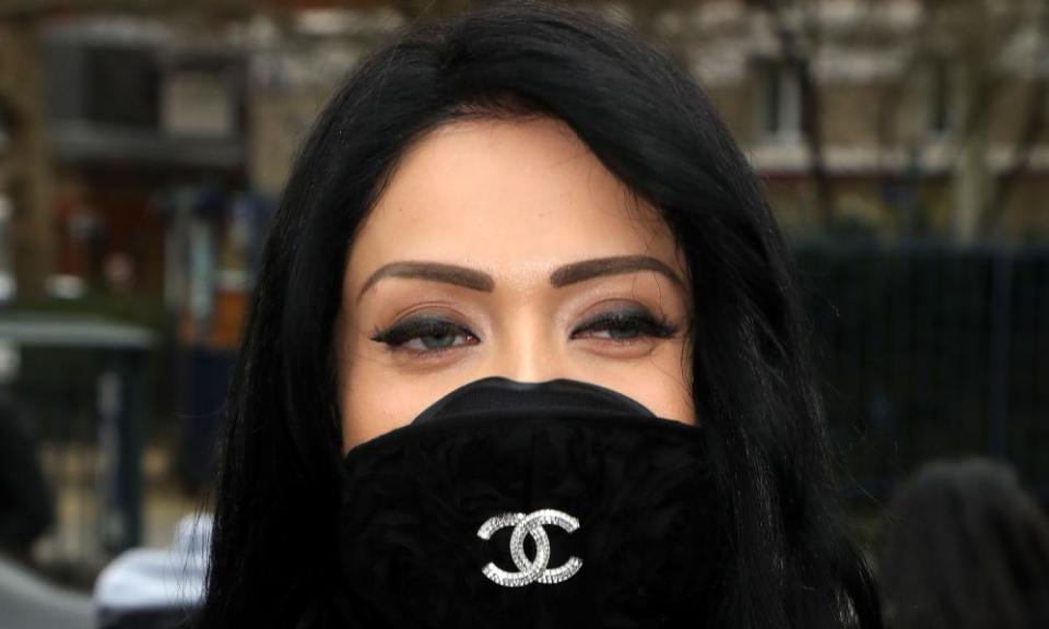 A woman in a Chanel Mask makes her way to the Balmain show.