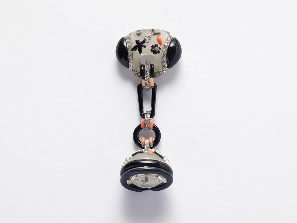 Bucherer — Lapel watch, Switzerland, c. 1925, platinum, diamonds, onyx, coral, rock crystal from the Pennisi Collection.<br> 