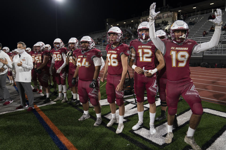 El Modena players react to a touchdown scored against El Dorado during their high school football game in Orange, Calif., Friday, March 19, 2021. (AP Photo/Jae C. Hong)