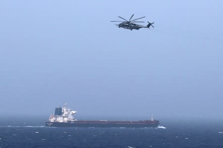 A U.S CH-53E Super Stallion aircraft flies over a tanker in the Arabian Sea off Oman