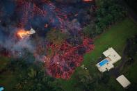 <p>Lava from a robust fissure eruption on Kilauea’s east rift zone consumes a home, then threatens another, near Pahoa, Hawaii, May 6, 2018. (Photo: Bruce Omori/Paradise Helicopters/EPA-EFE/REX/Shutterstock) </p>