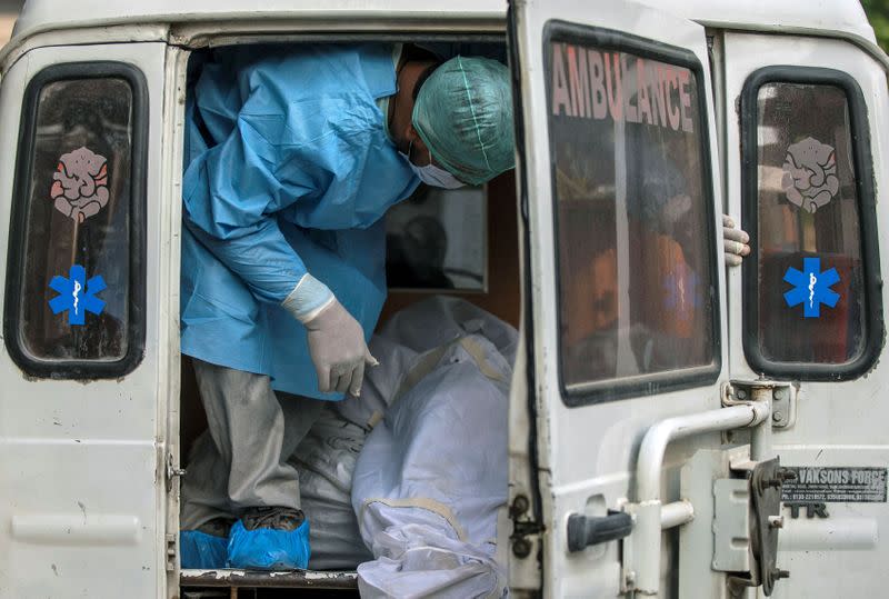 Mohammad Aamir Khan, an ambulance driver, takes out bodies of people who died due to the coronavirus disease for their cremation at a crematorium in New Delhi