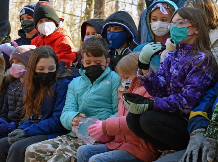 Moharimet Elementary School students work together in an attempt to pull apart a pair of ice blocks that were melted together.