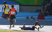 2016 Rio Olympics - Athletics - Preliminary - Men's 5000m Round 1 - Olympic Stadium - Rio de Janeiro, Brazil - 17/08/2016. Hassan Mead (USA) of USA falls over after colliding with Mo Farah (GBR) of Britain. REUTERS/David Gray