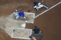 Chicago Cubs' Seiya Suzuki slides safely home after hitting an inside-the-park home run during the ninth inning of a baseball game against the Milwaukee Brewers Monday, July 4, 2022, in Milwaukee. (AP Photo/Morry Gash)