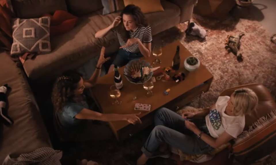 Alice, Nat, and Gigi talking around the table with beers