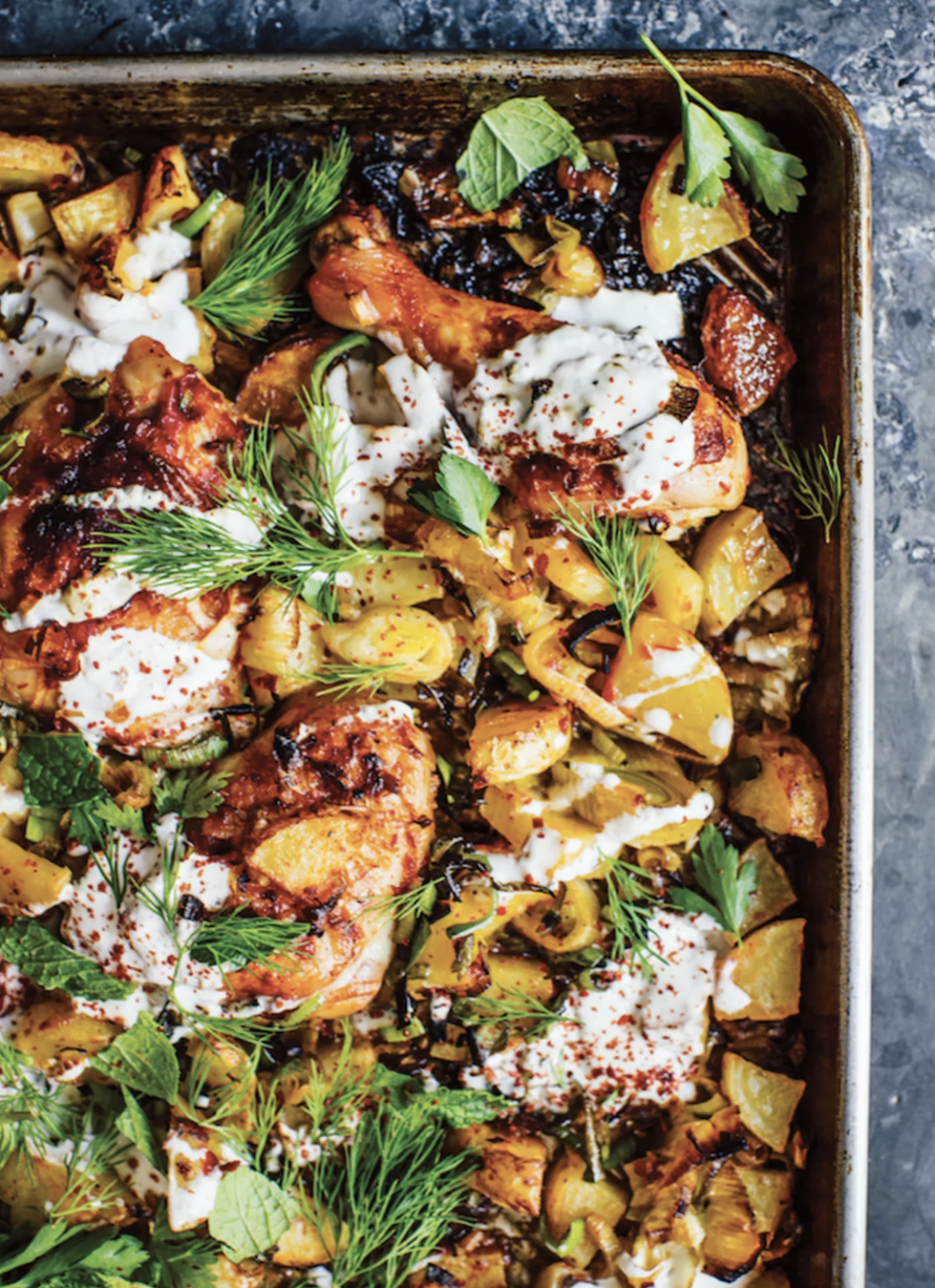 sheet pan chicken dish with potatoes and yogurt drizzle