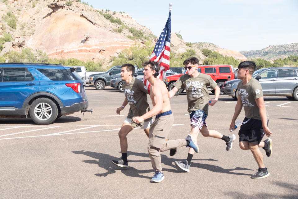 The first team of high school wrestlers push through the final leg of the Iwo Jima Flag Run Saturday at Palo Duro Canyon.