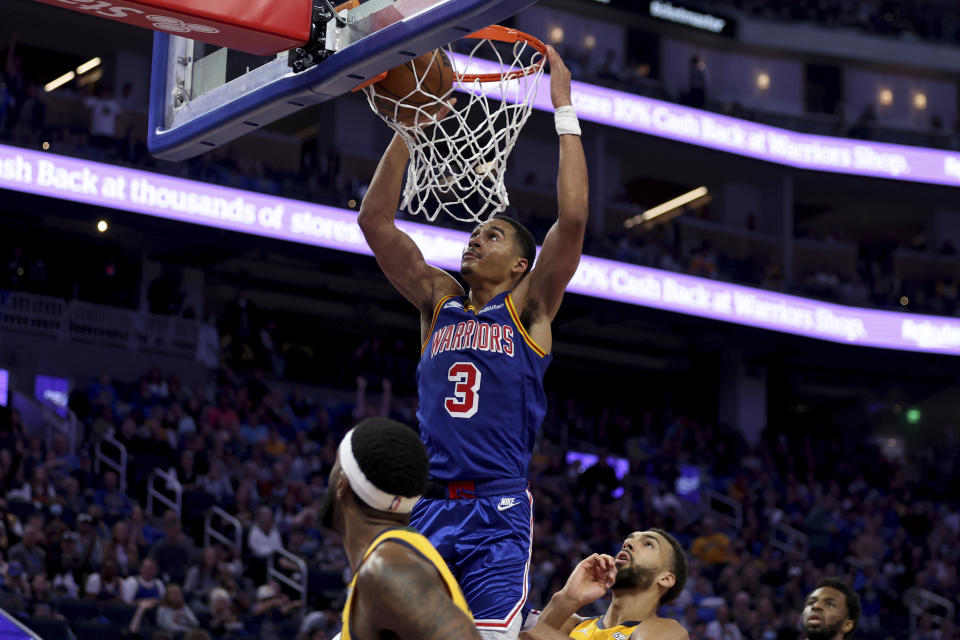 Golden State Warriors guard Jordan Poole (3) dunks against Utah Jazz center Rudy Gobert, center right, during the first half of an NBA basketball game in San Francisco, Saturday, April 2, 2022. (AP Photo/Jed Jacobsohn)