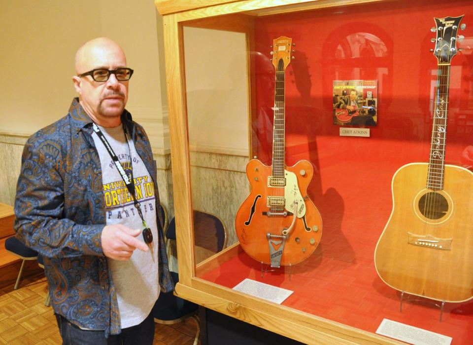 This April 22, 2013 photo shows guitarist Robert Johnson, who played in the 1970s with Isaac Hayes and John Entwistle's Ox, talking about the Chet Atkins and Johnny Cash guitars he donated to the National Music Museum in Vermillion, S.D. Johnson also donated a guitar played by Elvis Presley during his final tour and a harmonic played by Bob Dylan. (AP Photo/Dirk Lammers)