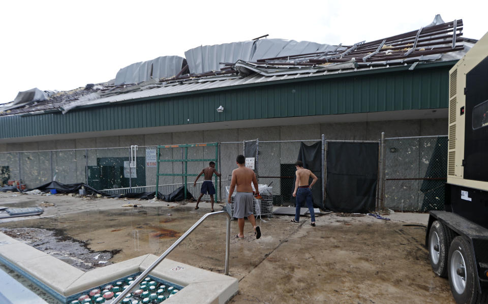 Mosley high football team members arrive for practice at their heavily damaged school, in the aftermath of Hurricane Michael in Lynn Haven, Fla., Friday, Oct. 19, 2018. (AP Photo/Gerald Herbert)