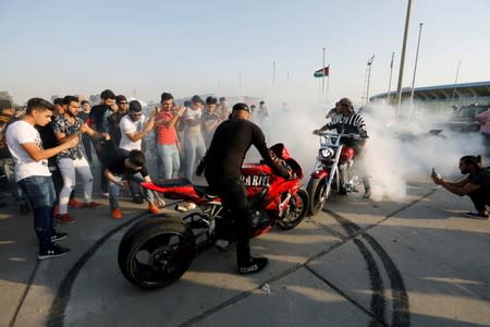 A biker wheelspins on his motorbike during a car and motorbike show outside the closed Hall of Shaab Stadium in Baghdad