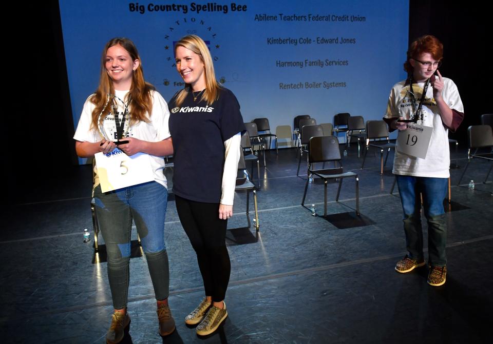 Tessa Jones (left) holds the trophy given to her by Amanda Wiskow, the spelling bee committee chairwoman, after winning the Kiwanis Club of Abilene 23rd Annual Big Country Spelling Bee on Feb. 26. Levi Gorman (right) was named runnerup.