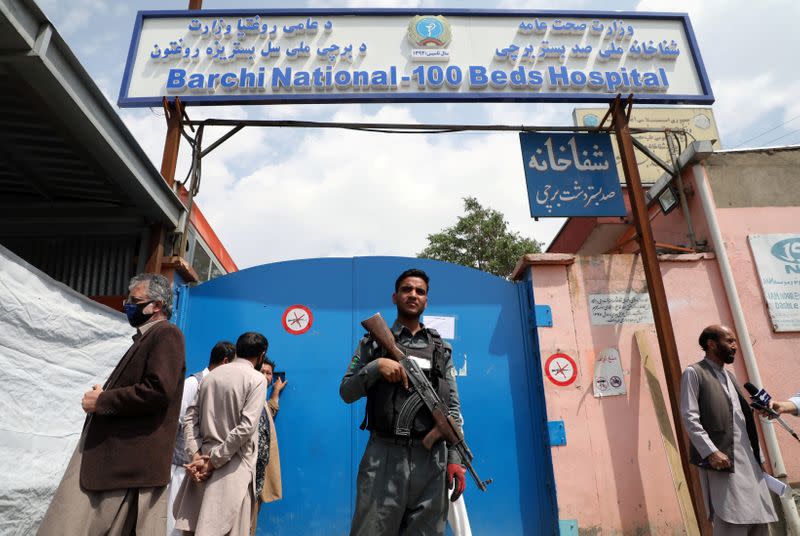 An Afghan policeman keeps watch outside of a hospital which came under attack in Kabul