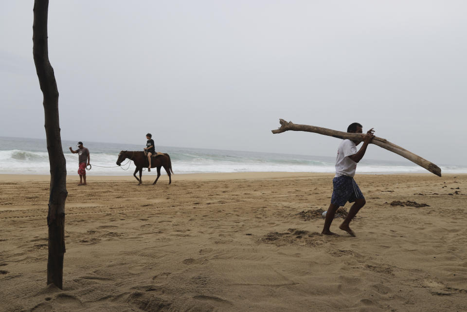 A tourist rides a horse at a beach in Acapulco, Mexico, Tuesday, Oct. 24, 2023. Hurricane Otis has strengthened from tropical storm to a major hurricane in a matter of hours as it approaches Mexico's southern Pacific coast where it was forecast to make landfall near the resort of Acapulco early Wednesday. (AP Photo/Bernardino Hernandez)