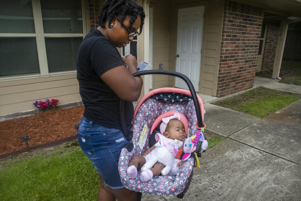 Tyesha Young, who lost her hospital job during the pandemic, arrives home with her baby Jalayah Johnson in Waggaman, La., Friday, July 2, 2021. More than $7,000 behind on rent, Young had hoped a program in Louisiana would bail her out and allow her family to avert eviction in the coming weeks. But the 29-year-old mother of two from Jefferson Parish is still waiting to hear whether any of the $308 million available from the state for rental assistance and utility payments will give her a lifeline. She applied for money last year but never heard anything. ​(AP Photo/Sophia Germer)