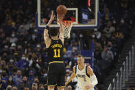 Golden State Warriors guard Klay Thompson (11) shoots against Dallas Mavericks center Kristaps Porzingis (6) during the first half of an NBA basketball game in San Francisco, Tuesday, Jan. 25, 2022. (AP Photo/Jed Jacobsohn)