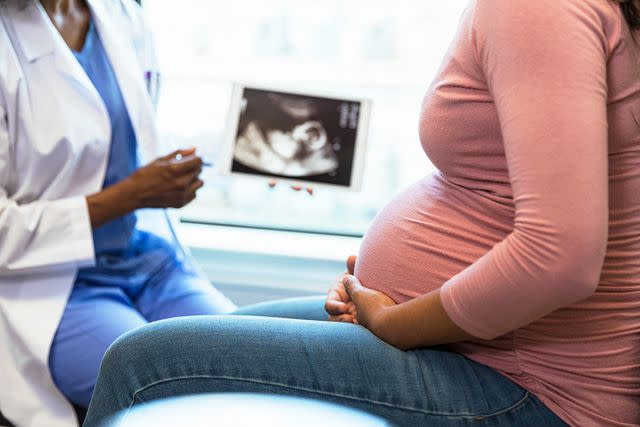 <p>Getty</p> Stock photo of a pregnant woman and her doctor.
