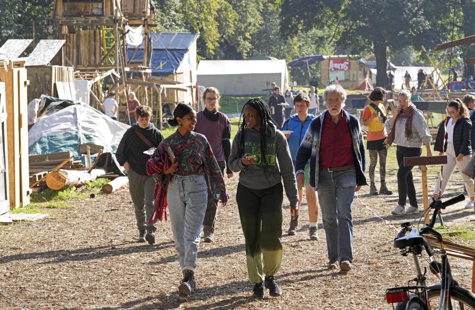 Climate activist Vanessa Nakate from Uganda, front right, visits an activists camp near the Garzweiler open-cast coal mine in Luetzerath, western Germany, Saturday, Oct. 9, 2021. The village of Luetzerath, now almost entirely abandoned as the mine draws ever closer, will be the latest village to disappear as coal mining at the Garzweiler mine expands. Garzweiler, operated by utility giant RWE, has become a focus of protests by people who want Germany to stop extracting and burning coal as soon as possible. (AP Photo/Martin Meissner)