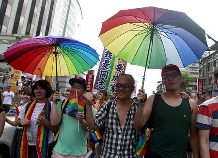 Participants hold rainbow umbrellas during a rally to demanding the Taiwanese government to legalize same-sex marriage in front of the ruling Nationalist Kuomintang Party headquarters in Taipei, Taiwan, July 11, 2015. REUTERS/Pichi Chuang