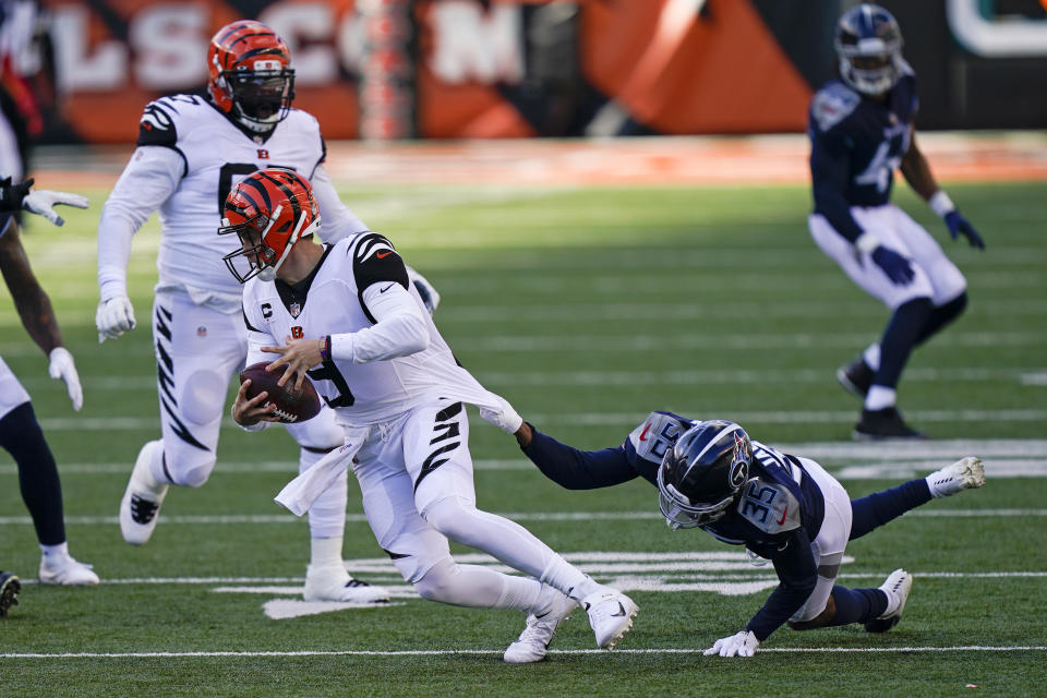 Cincinnati Bengals quarterback Joe Burrow (9) runs against Tennessee Titans' Chris Jackson (35) during the second half of an NFL football game, Sunday, Nov. 1, 2020, in Cincinnati. (AP Photo/Bryan Woolston)