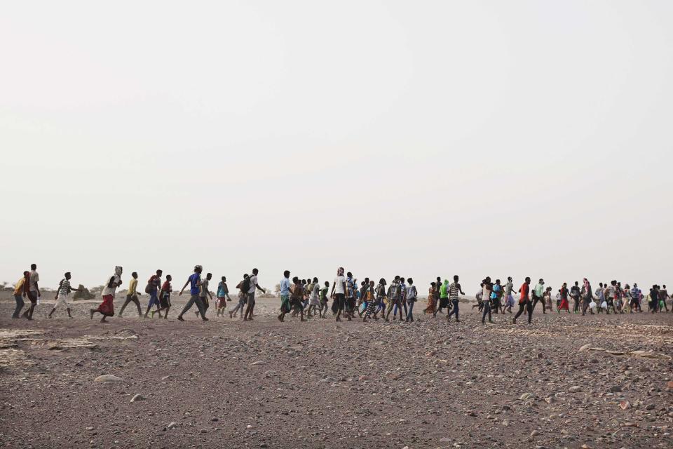 In this July 14, 2019 photo, smugglers lead Ethiopian migrants in Obock, Djibouti. The flow of migrants taking this route has grown. According to the U.N.'s International Organization for Migration, 150,000 arrived in Yemen from the Horn of Africa in 2018, a 50% jump from the year before. The number in 2019 was similar. They dream of reaching Saudi Arabia, and earning enough to escape poverty by working as laborers, housekeepers, servants, construction workers and drivers. (AP Photo/Nariman El-Mofty)