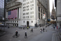FILE- In this March 18, 2020, file photo a few people walk on Wall Street in front of the New York Stock Exchange in New York. There are emerging signs that any recovery will fail to match the speed and severity of the economic collapse that occurred in just a few weeks. (AP Photo/Mark Lennihan, File)