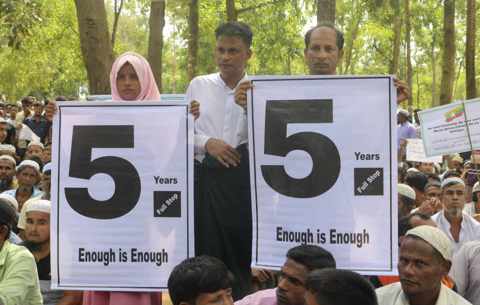 Rohingya refugees hold placards as they gather to mark the fifth anniversary of their exodus from Myanmar to Bangladesh, at a Kutupalong Rohingya refugee camp at Ukhiya in Cox's Bazar district, Bangladesh, Thursday, Aug. 25, 2022. Hundreds of thousands of Rohingya refugees on Thursday marked the fifth anniversary of their exodus from Myanmar to Bangladesh, while the United States, European Union and other Western nations pledged to continue supporting the refugees' pursuit of justice in international courts.(AP Photo/ Shafiqur Rahman)