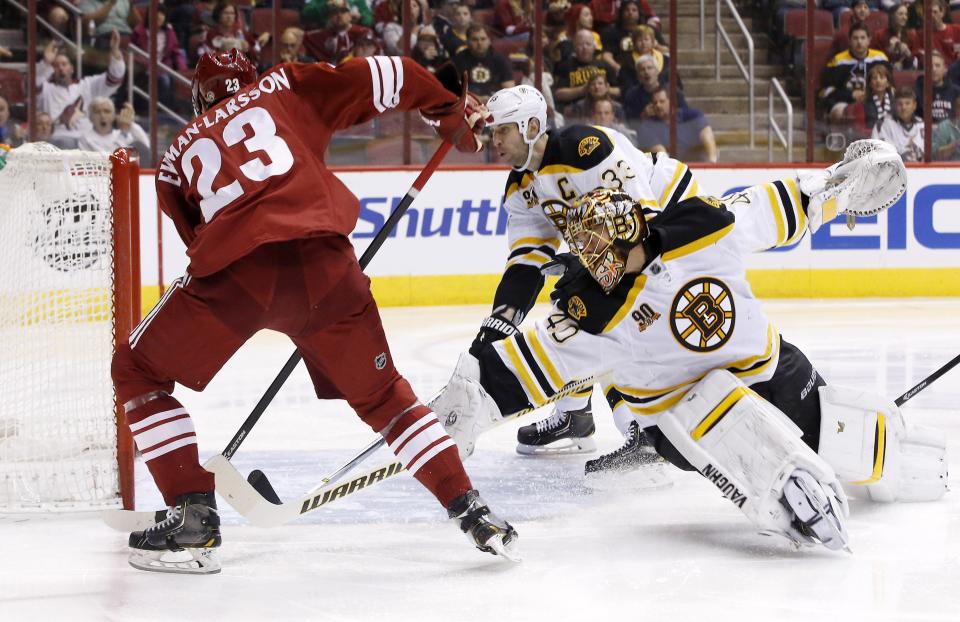 Phoenix Coyotes' Oliver Ekman-Larsson (23), of Sweden, scores a goal against Boston Bruins' Tuukka Rask (40), of Finland, as Bruins' Zdeno Chara (33), of the Czech Republic, arrives late to defend during the second period of an NHL hockey game on Saturday, March 22, 2014, in Glendale, Ariz. (AP Photo/Ross D. Franklin)