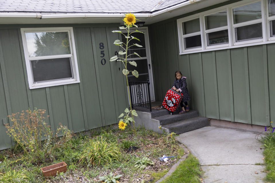 Adeline Alderson, 5, drags a suitcase out of her family's house in Baker City, Ore., on Friday, Sept. 1, 2023. The family is headed to Idaho where Adeline's mother, Alisha is to give birth later in September. (AP Photo/Kyle Green)