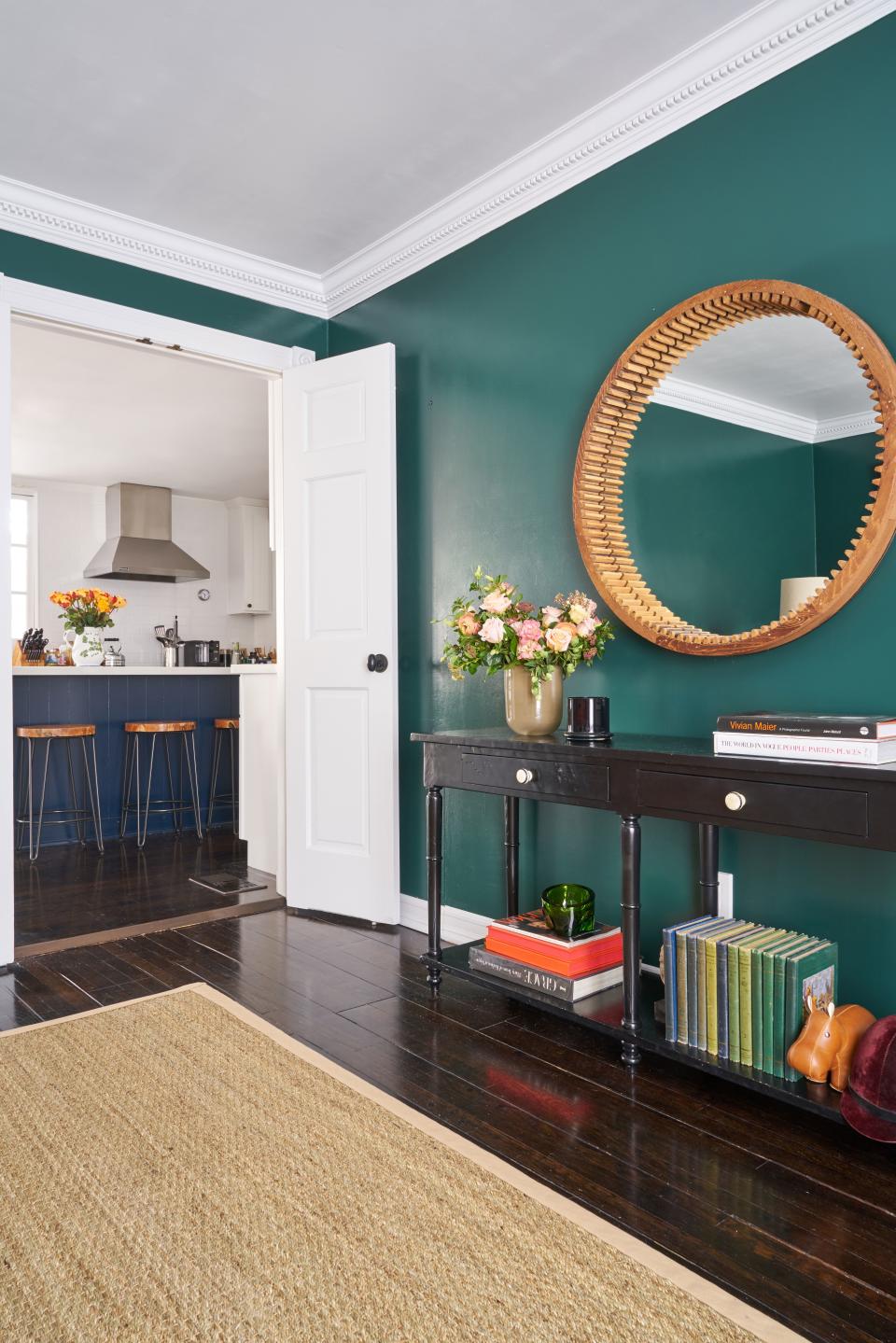 The mirror in the dining room, painted in Benjamin Moore’s Hunter Green, is made from an old wooden shipping mold.