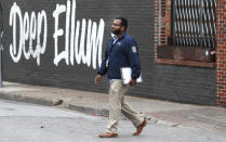FILE - In this March 31, 2020, file photo, City of Dallas code compliance officer Eldho Babu checks on businesses amid concerns of COVID-19 spreading in the Deep Ellum section of Dallas. Resident snitches are emerging as enthusiastic allies as cities, states and countries work to enforce directives meant to limit person-to-person contact amid the virus pandemic that already has claimed tens of thousands of lives worldwide. (AP Photo/LM Otero, File)