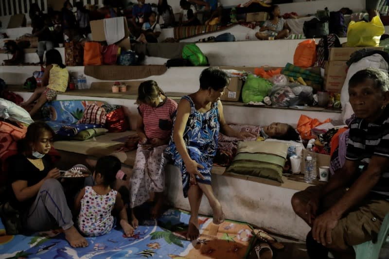 Manimtim holds her bedridden mother in an evacuation center for residents affected by the Taal Volcano eruption in Santo Tomas