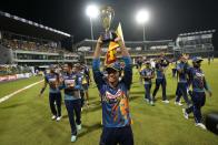 Sri Lanka's Dunith Wellalage holding the winner's trophy along with other team members acknowledges the crowd after winning the one-day international cricket series with Australia by 3-2 match in Colombo, Sri Lanka, Friday, June 24, 2022. (AP Photo/Eranga Jayawardena)