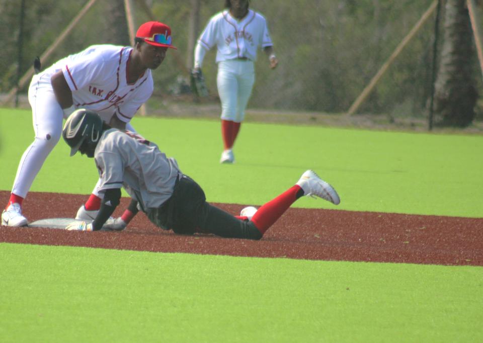 Ribault runner Braylin Clarke (5) slides into second base as Raines shortstop Malik Morrison (3) tries to field the throw during the High School Heritage Classic.