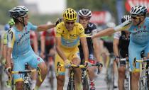 Italy's Vincenzo Nibali, centre, is congratulated by teammates as he crosses the finish line to win the 2014 Tour de France after the twenty-first and last stage of the Tour de France cycling race over 137.5 kilometers (85.4 miles) with start in Evry and finish in Paris, France, Sunday, July 27, 2014. (AP Photo/Christophe Ena)