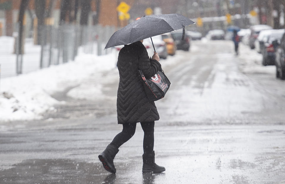 A person uses an umbrella as rain falls in Montreal, Friday, Dec. 23, 2022, as a storm system bears down on the region. (Graham Hughes /The Canadian Press via AP)