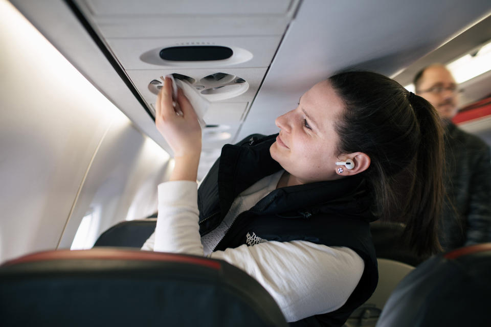 Emily Blumberg de Chicago, limpia con una toallita húmeda su espacio en un vuelo de American Airlines que se dirige a Washington desde el Aeropuerto Metropolitano de Detroit en Romulus, Míchigan, el martes 3 de marzo de 2020. (Alyssa Schukar/The New York Times)