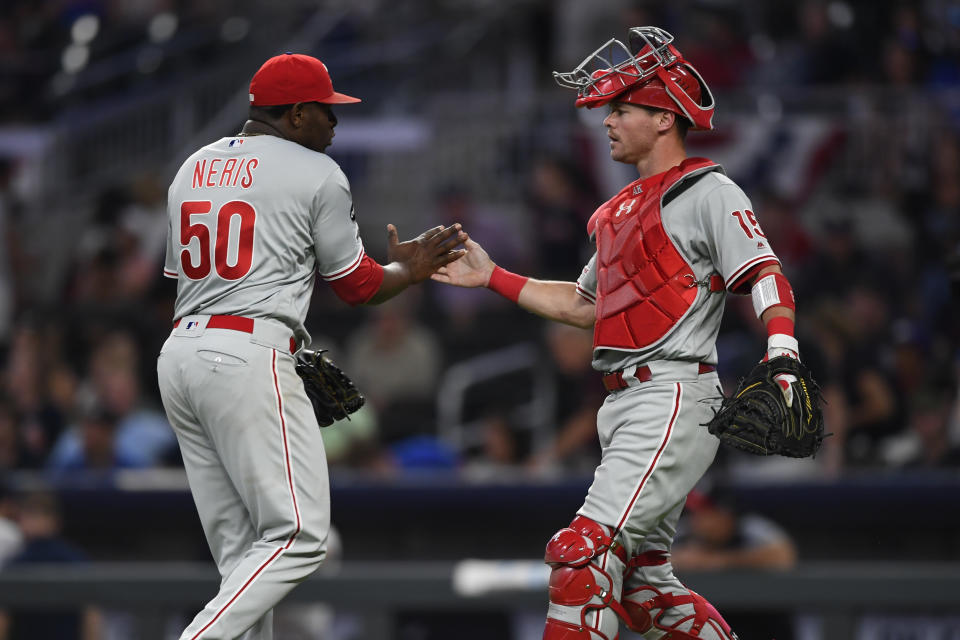 Philadelphia Phillies pitcher Hector Neris (50) and catcher Andrew Knapp congratulate each other after the ninth inning of a baseball game against the Atlanta Braves, Saturday, June 15, 2019, in Atlanta. (AP Photo/John Amis)