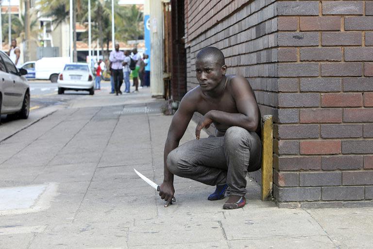 A foreign national holds a knife following clashes between a group of locals and police in Durban on April 14 ,2015 amidst violence against foreign nationals living in Durban