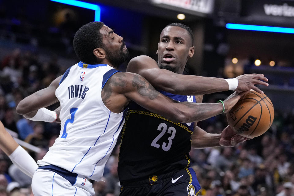 Dallas Mavericks guard Kyrie Irving (2) knocks the ball away from Indiana Pacers forward Aaron Nesmith (23) during the second half of an NBA basketball game in Indianapolis, Monday, March 27, 2023. The Mavericks defeated the Pacers 127-104. (AP Photo/Michael Conroy)