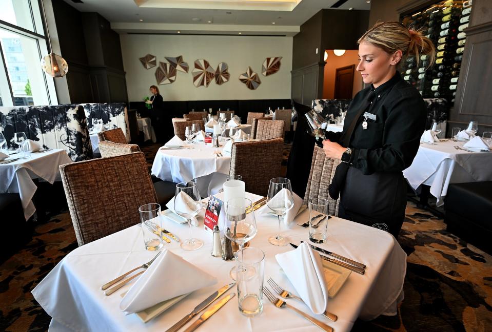 Ruth's Chris Steak House server Samantha Ryan of Worcester polishes glassware and utensils in preparation of opening.