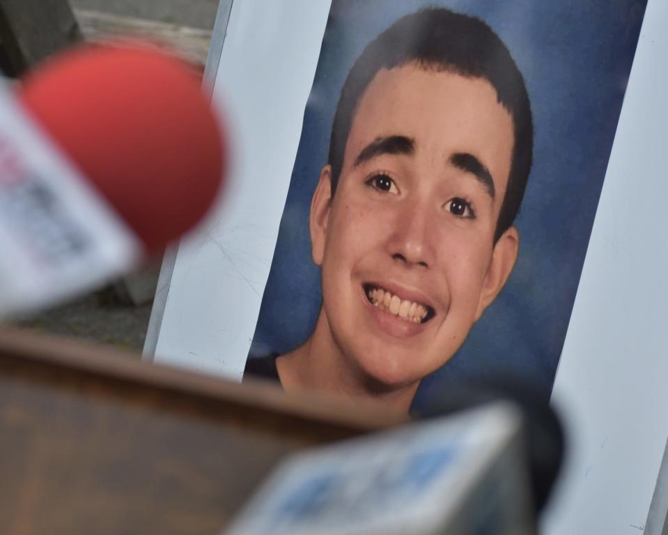 A photo of David Almond is placed behind the podium at Heritage State Park during a ceremony on Friday, May 27, 2022 dedicating a tree and bench to his memory. The  Fall River autistic teen died in October 2020 at the age of 14 from starvation and neglect.