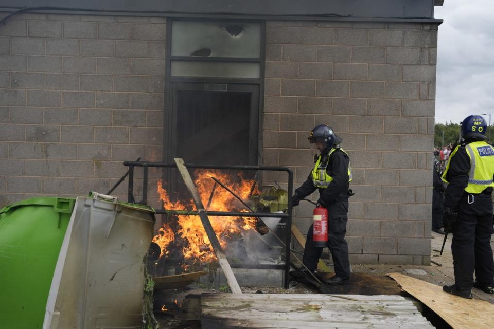 A fire is extinguished by police outside the Holiday Inn Express in Rotherham (PA Wire)