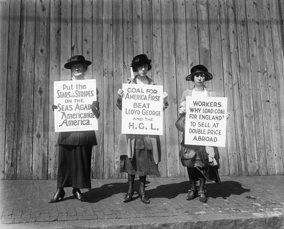 Boston women pickets are centering their drive to prevent the export of coal to that England on Sep. 22, 1920. Three of the women pickets are shown patrolling the waterfront in East Boston. The picketing is designed, the leaders said, to thwart the effort of Lloyd George to import 150,000,000 tons of coal from America to England thus breaking the strike of British Coal Miners.