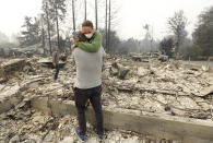 <p>Todd Caughey, foreground, hugs his daughter Ella as they visit the site of their home destroyed by fires in Kenwood, Calif., Tuesday, Oct. 10, 2017. (Photo: Jeff Chiu/AP) </p>