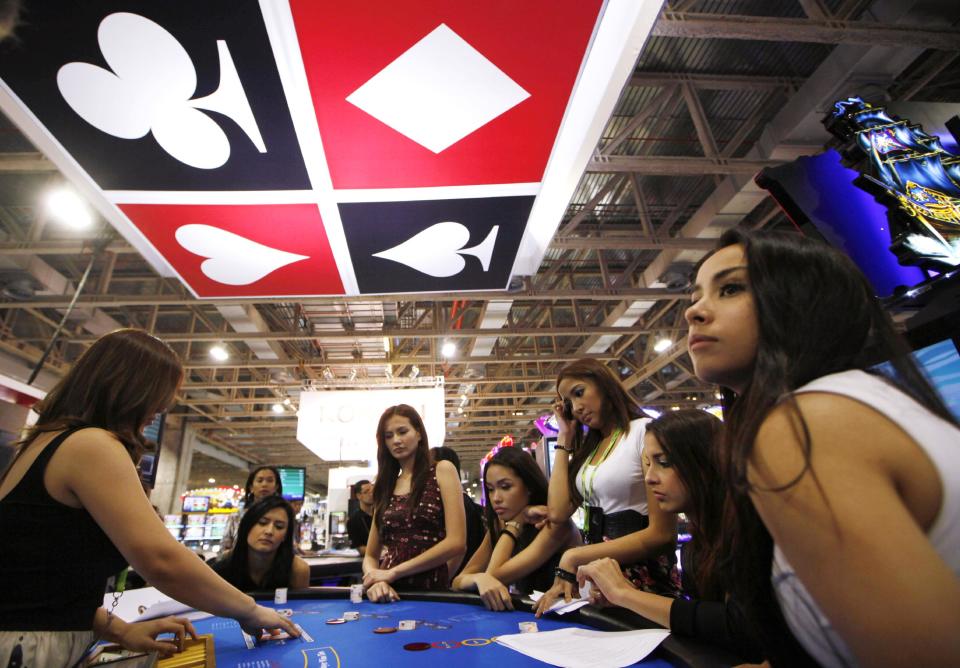 FILE - In this May 22, 2012 file photo, attendants learn poker at a gambling table at Gaming Expo Asia in Macau. In the Philippines, a $4 billion casino project will soon rise from reclaimed land on Manila Bay. In South Korea, foreign investors will break ground next year on a clutch of casino resorts offshore. In the Philippines, a $4 billion casino project will soon rise from reclaimed land on Manila Bay. In South Korea, foreign investors will break ground next year on a clutch of casino resorts offshore. And on the eastern edge of Russia, authorities plan a resort zone aimed at drawing Chinese high-rollers. The projects are part of a casino building boom rolling across Asia, where governments are trying to develop their tourism markets to capture increasingly affluent Asians with a penchant for gambling. (AP Photo/Kin Cheung, File)