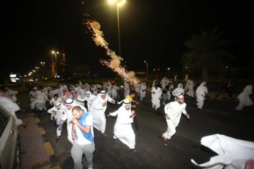 Kuwaiti opposition supporters run for cover during a protest in Kuwait City last month against the decision by Emir Sheikh Sabah al-Ahmad al-Sabah to amend the electoral law despite it having been confirmed by a court in September